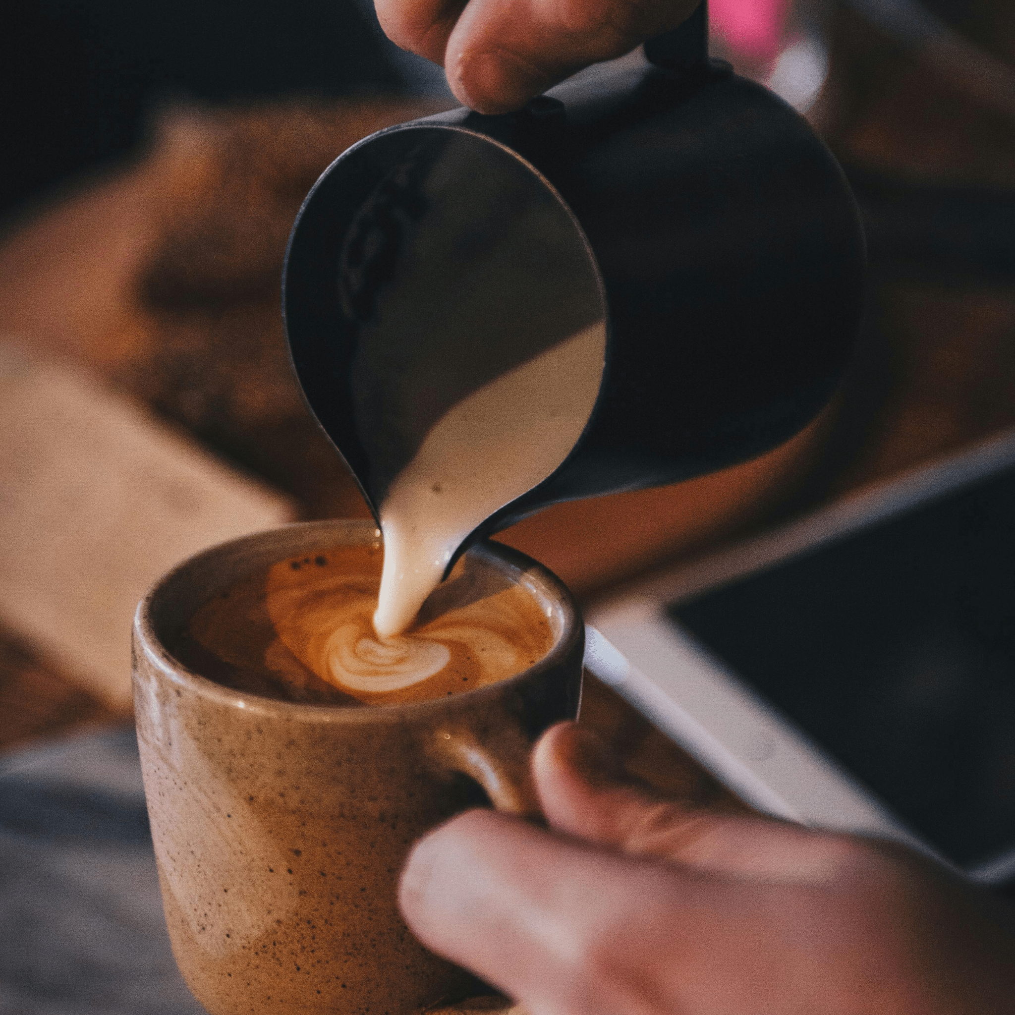 Barista pouring freshly ground coffee surrounded by espresso accessories