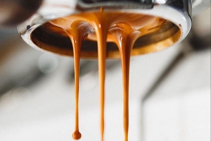Espresso extracting from a bottomless portafilter into a cup