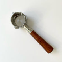 画像をギャラリービューアに読み込む, A Delonghi Dedica bottomless portafilter with an almond solid wood handle and stainless steel basket.
